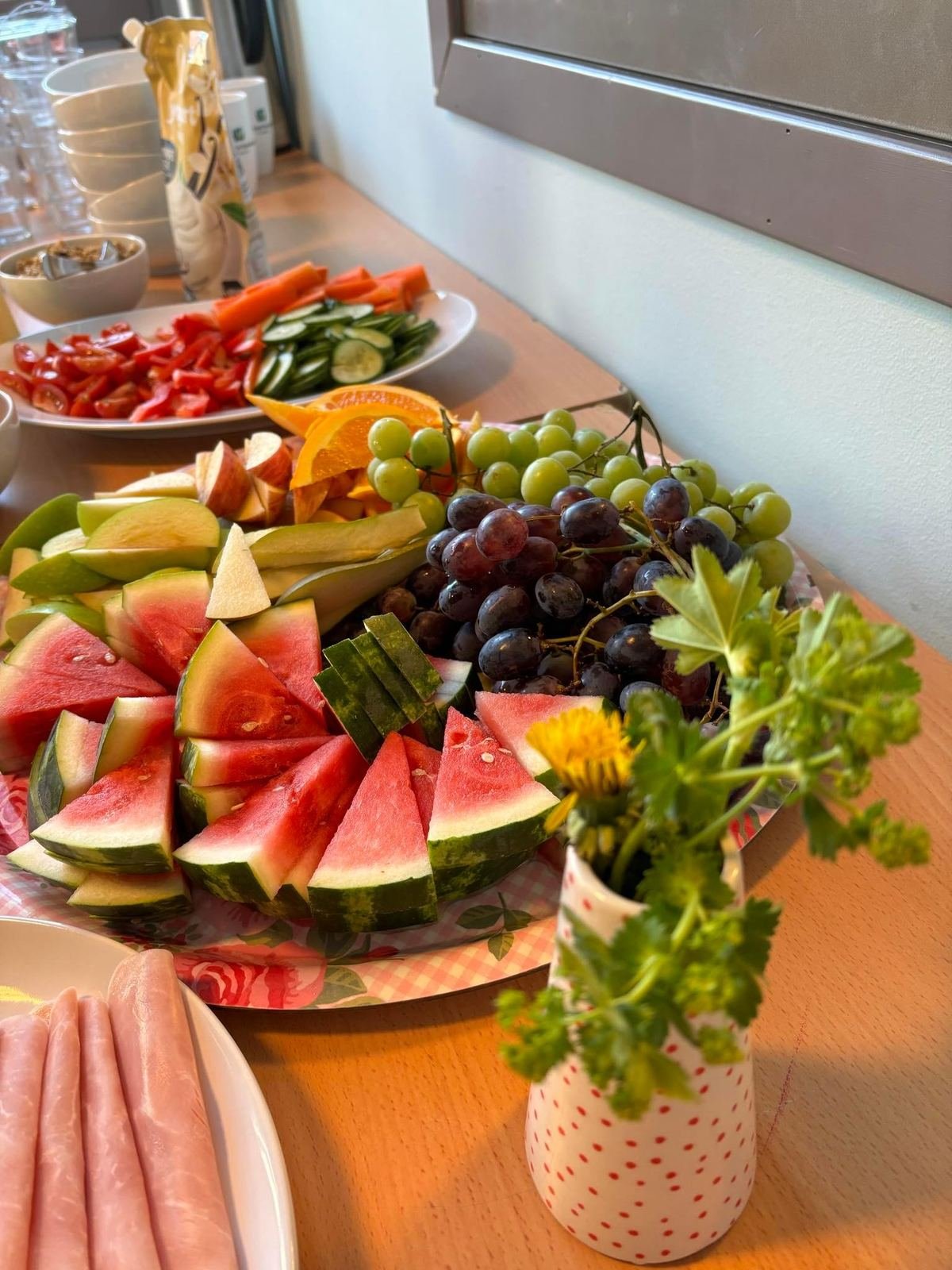 Buffet med fruktfat, pålegg og blomster fra kveldsmaten